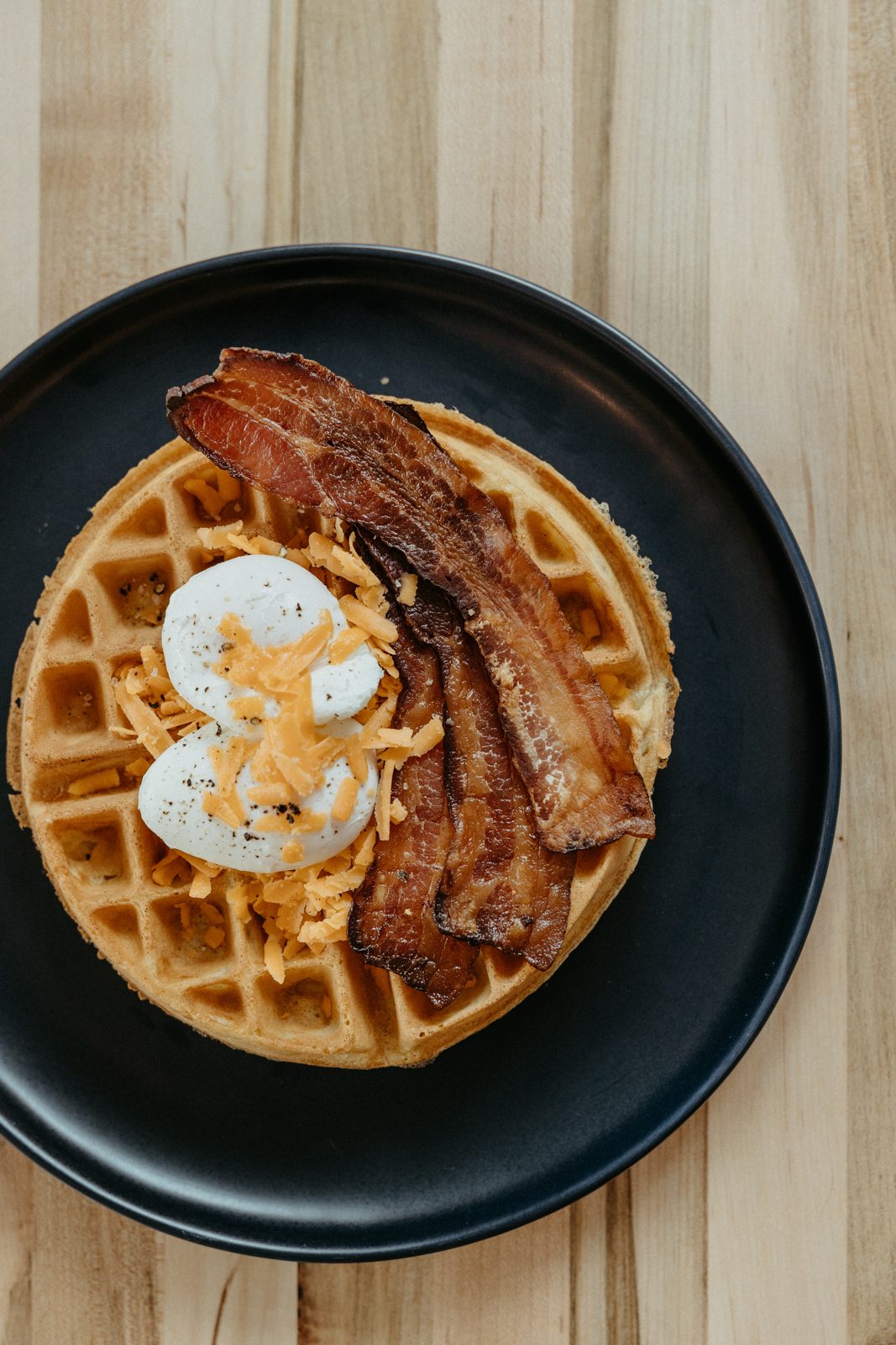Canadian brunch waffle with bacon, cheddar and poached eggs